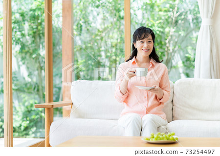 一位在客廳放鬆的中年婦女 一位在客廳放鬆的中年婦女 73254497