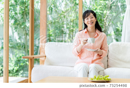 一位在客廳放鬆的中年婦女 一位在客廳放鬆的中年婦女 73254498