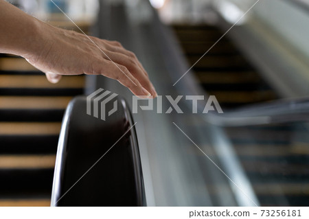 Close up,Hand of female with handrail of escalator,avoiding or not touching the handrail while using the escalator,dirt and accumulation of a pathogens,bacteria,virus that can cause contagious disease Close up,Hand of female with handrail of escalator,avoiding or not touching the handrail while using the escalator,dirt and accumulation of a pathogens,bacteria,virus that can cause contagious disease 73256181