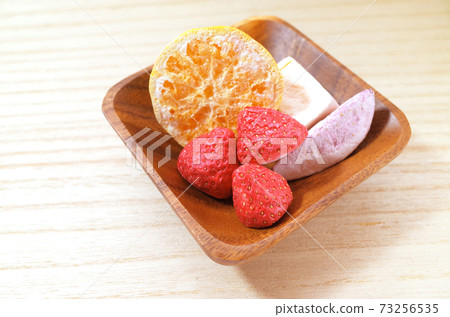 Freeze-dried fruit on a wooden plate 73256535