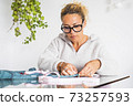 Adult woman concentrated in home work activity like tailor - clothing job with single female people working indoor in diy hand made clothes making of 73257593