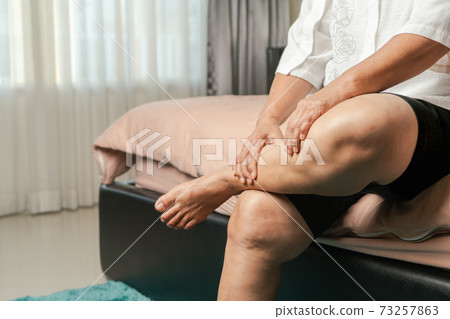 leg cramp, senior woman suffering from leg cramp pain at home, health problem concept 73257863