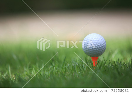 Golf ball on tee ready to be shot , for holiday season concept of golf course background Golf ball on tee ready to be shot , for holiday season concept of golf course background 73258081
