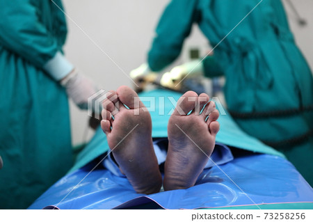 Team of professional surgeons performing operation in hospital , they are holding defibrillator and help while patient will die operation room at hospital Team of professional surgeons performing operation in hospital , they are holding defibrillator and help while patient will die operation room at hospital 73258256