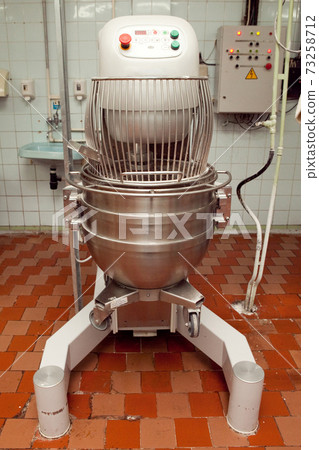 The process of making cookie dough in an industrial kneading machine at the factory 73258712