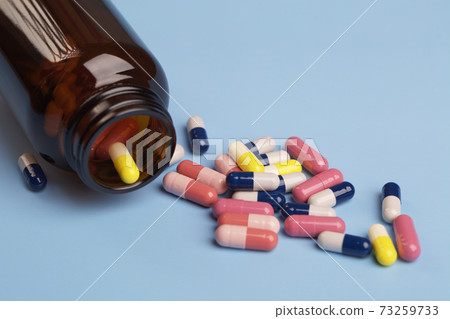 Various medicine capsules and bottle of pills 73259733
