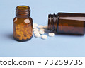 Medicine white pills and glass pills of bottles 73259735
