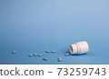Medicine blue pills and white bottle 73259743