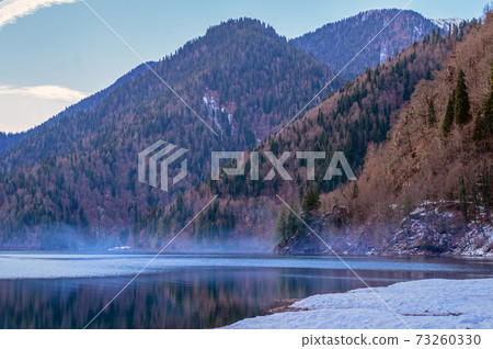 Mountain lake on the background of mountains and blue sky Mountain lake on the background of mountains and blue sky 73260330