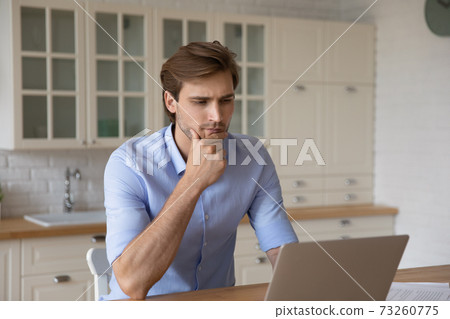 Pensive young man look at laptop screen thinking 73260775