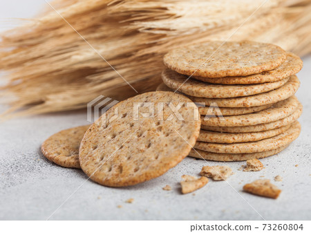 Stack of round organic crispy wheat and corn flatbread crackers with sesame and salt on light Stack of round organic crispy wheat and corn flatbread crackers with sesame and salt on light 73260804