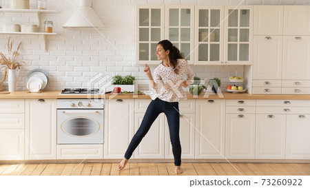 Happy female renter enjoy dancing in home kitchen 73260922