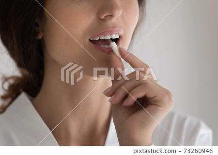 Close up of woman take vitamins for healthy skin Close up of woman take vitamins for healthy skin 73260946