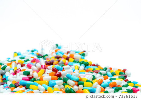 Selective focus on pile of multi-colored antibiotic capsule pills. Antimicrobial capsule pills on white background. Antibiotic resistance concept. Pharmacy drugstore products. Pharmaceutical industry. 73261615