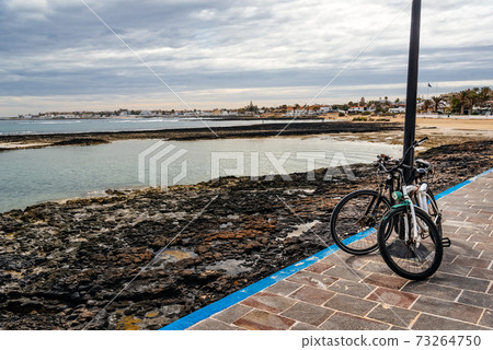 Bicycles parked in the promenade of the bay of Corralejo in Fuerteventura Bicycles parked in the promenade of the bay of Corralejo in Fuerteventura 73264750