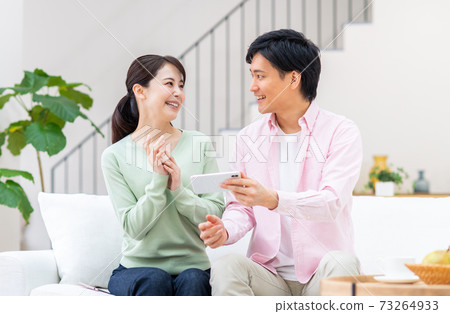 年輕的夫婦在智能手機上觀看視頻 年輕的夫婦在智能手機上觀看視頻 73264933