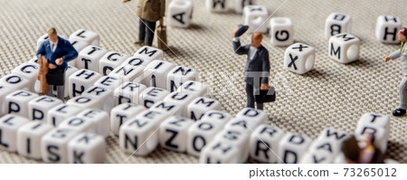 set of popular crypto coins words forming thematical crossword made of white cubes with black capital letters and miniature businessmen figurines having a team meeting 73265012