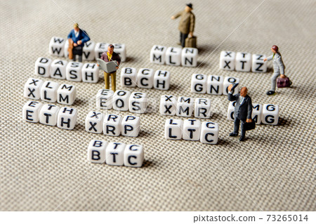 set of popular crypto coins forming rows made of white cubes with black capital letters and miniature businessmen figurines having a team meeting 73265014