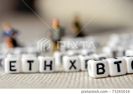 set of popular crypto coins forming rows made of white cubes with black capital letters and miniature businessmen figurines having a team meeting 73265016