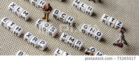 set of popular crypto coins forming rows made of white cubes with black capital letters and miniature businessmen figurines having a team meeting 73265017