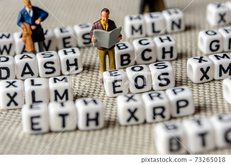 set of popular crypto coins forming rows made of white cubes with black capital letters and miniature businessmen figurines having a team meeting 73265018