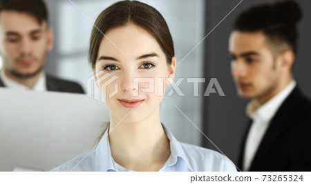 Business woman and group of diverse business people at the background in modern office. Multi ethnic teamwork and business concept 73265324