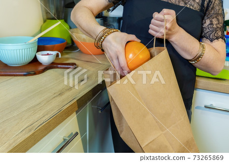 Woman take out fruits from paper bag Woman take out fruits from paper bag 73265869