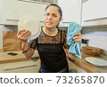 Angry woman smashing plate in kitchen 73265870