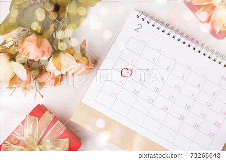 Calendar and flower with memo 14 February Valentine day on desk with blur bokeh background. 73266648