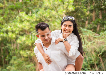 Asian couple love having fun. man and woman wearing casual clothing feeling happiness in park Asian couple love having fun. man and woman wearing casual clothing feeling happiness in park 73266917