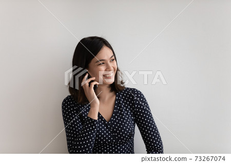 Smiling pretty young vietnamese asian woman involved in cellphone call. Smiling pretty young vietnamese asian woman involved in cellphone call. 73267074