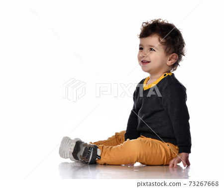 Side view of a handsome stylish baby boy sitting 73267668