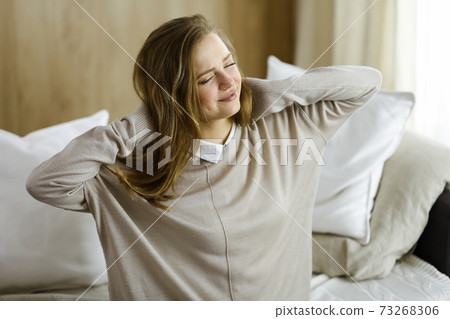 Tired woman massaging rubbing stiff sore neck tensed muscles fatigue from computer work in incorrect posture. Stay at home concept during Coronavirus pandemic and self isolation quarantine 73268306