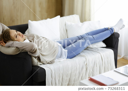 Happy brunette woman put hands behind head lying leaned on couch european female enjoy lazy weekend or vacation in cozy living room, housewife relaxing feels satisfied accomplish chores housework Happy brunette woman put hands behind head lying leaned on couch european female enjoy lazy weekend or vacation in cozy living room, housewife relaxing feels satisfied accomplish chores housework 73268311