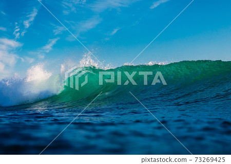 Surfing wave in ocean. Breaking turquoise wave sunny day 73269425