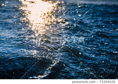 Waves at surface of ocean. Water texture with bokeh and drops Waves at surface of ocean. Water texture with bokeh and drops 73269426