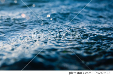 Waves at surface of ocean. Water texture with bokeh and drops Waves at surface of ocean. Water texture with bokeh and drops 73269428