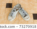 Old shoes and tiles floor. 73270918