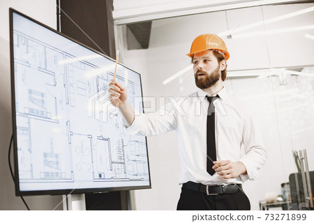 Young manager in the office with helmet Young manager in the office with helmet 73271899