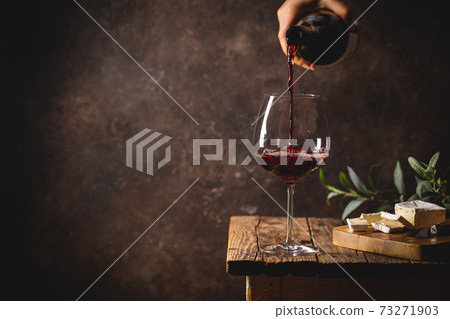 Pouring red wine into the glass Pouring red wine into the glass 73271903