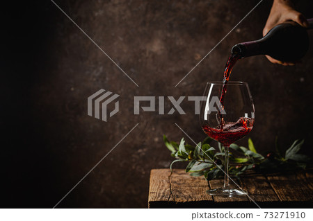 Pouring red wine into the glass Pouring red wine into the glass 73271910