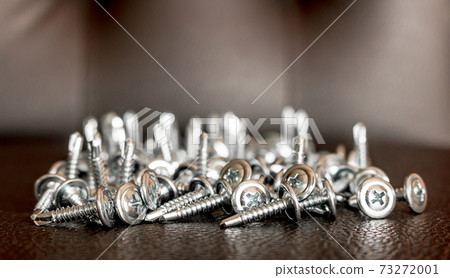 metal screws closeup on brown leather. metal screws closeup on brown leather. 73272001
