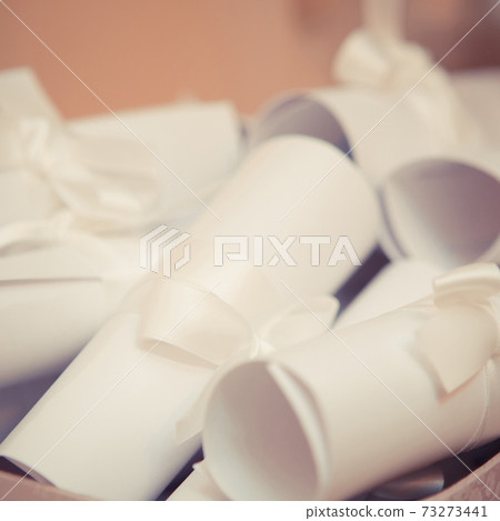 Creative invitations are roll up in the scrolls. 73273441