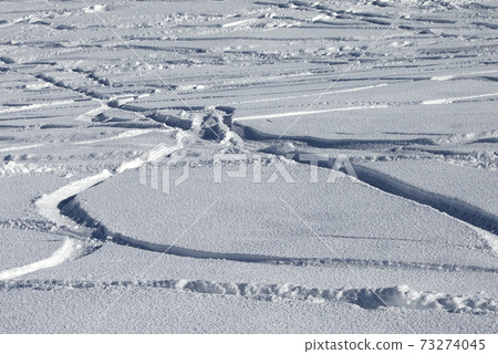 Trace of ski and snowboards in new-fallen snow 73274045