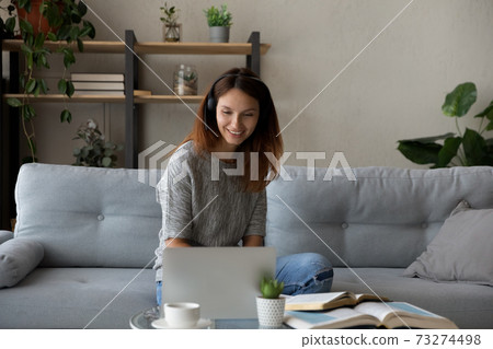 Smiling woman in headphones study online at home Smiling woman in headphones study online at home 73274498