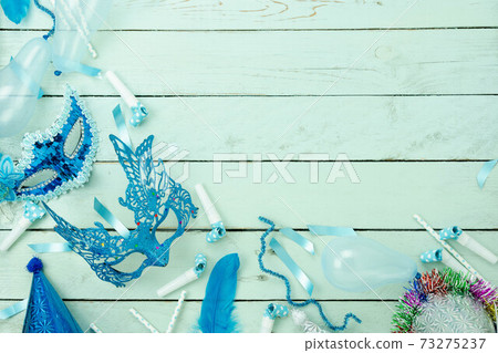 Table top view aerial image of beautiful colorful carnival festival background.Flat lay accessory object the several mask  decor confetti on modern blue wooden at home office desk studio.copy space. 73275237