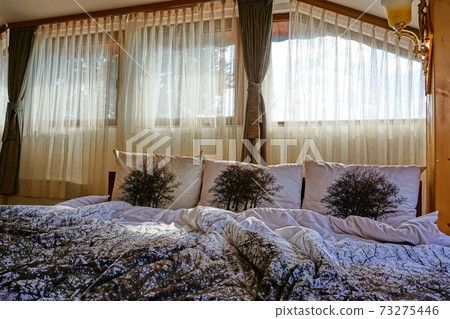 Undone bed in the morning in a cozy bedroom 73275446