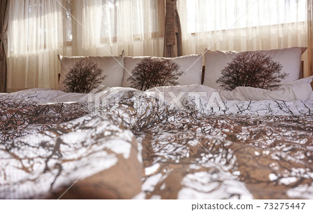 Undone bed in the morning in a cozy bedroom 73275447