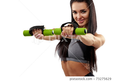 Focus on hands of an attractive young woman working out with dumbbells Focus on hands of an attractive young woman working out with dumbbells 73275629
