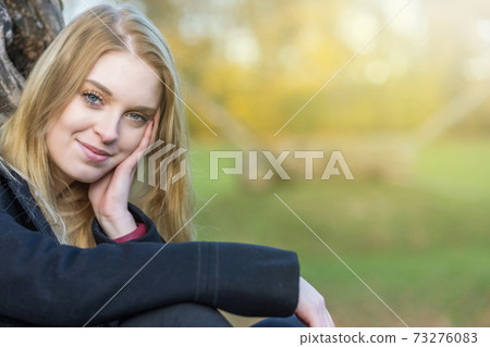 Portrait of young smiling girl in autumn park 73276083